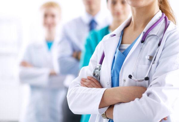 Attractive female doctor in front of medical group .